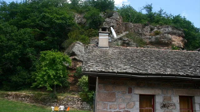 Maison en pierre au pied des rochers